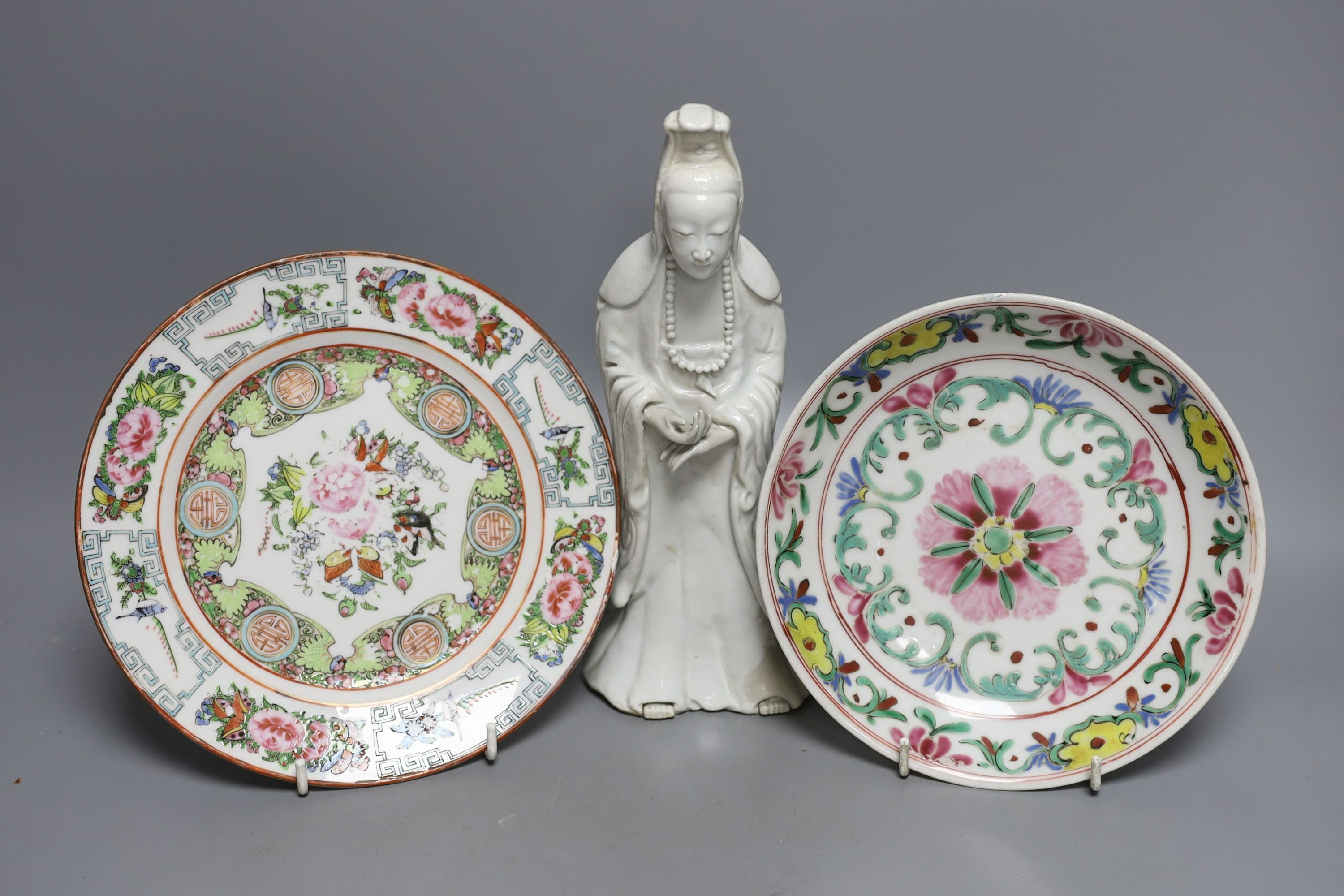 A Chinese blanc de chine figure of Guanyin, probably 18th century and two famille rose plates. Tallest 26cm